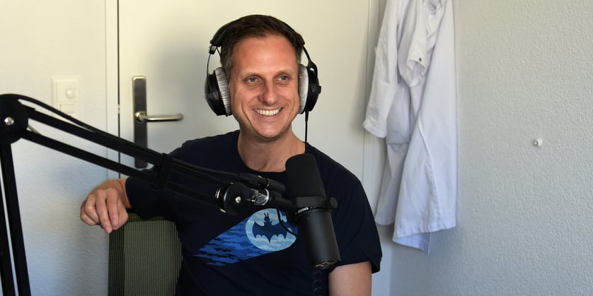 André Gehrz, Leitender Arzt Chirurgie Spital Emmental, mit Mikrofon bei Podcast-Aufnahme.