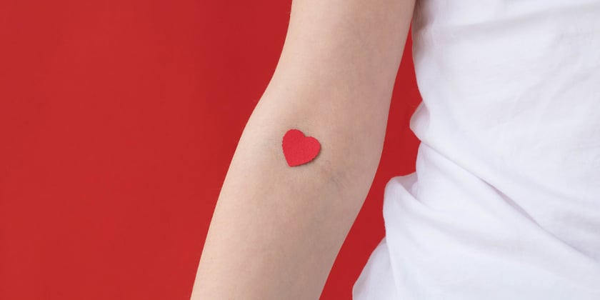 Der Arm eines Menschen mit einem roten Herzchen in der Ellbogenbeuge. 